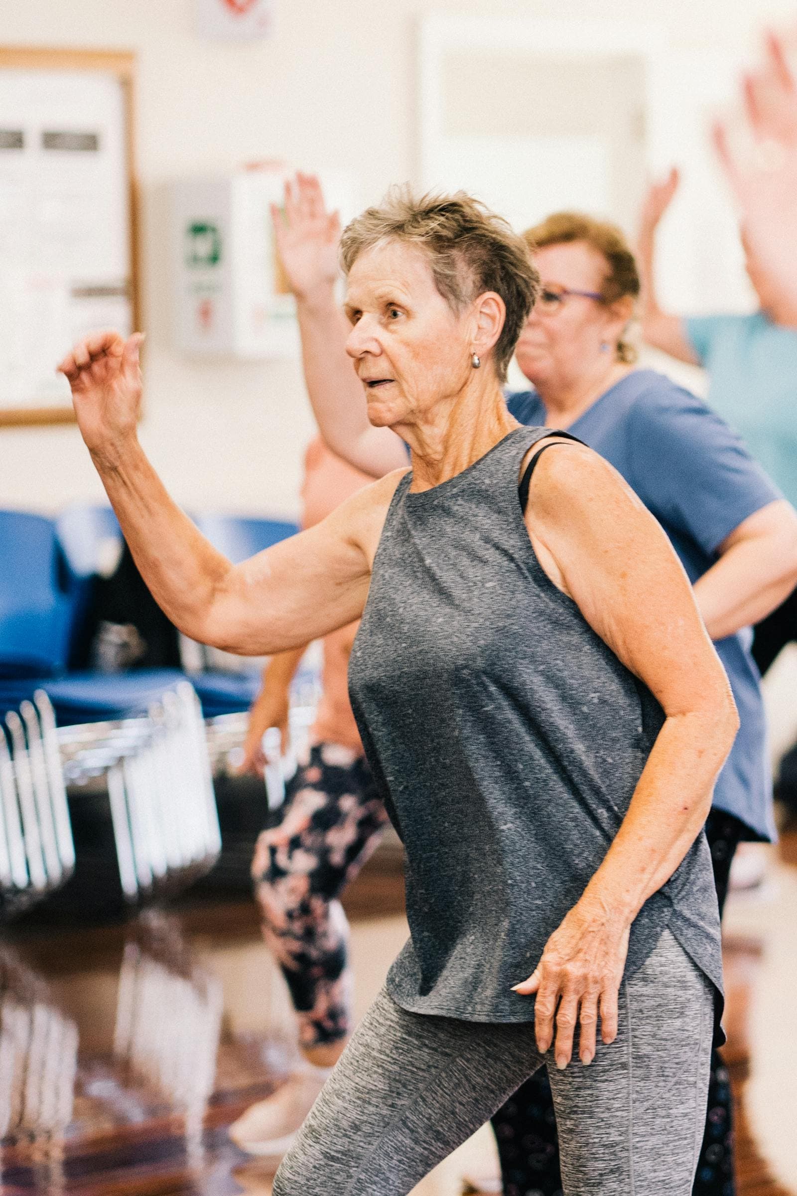 Senior women dance in a group fitness class — the kind of activity a companion caregiver supports.